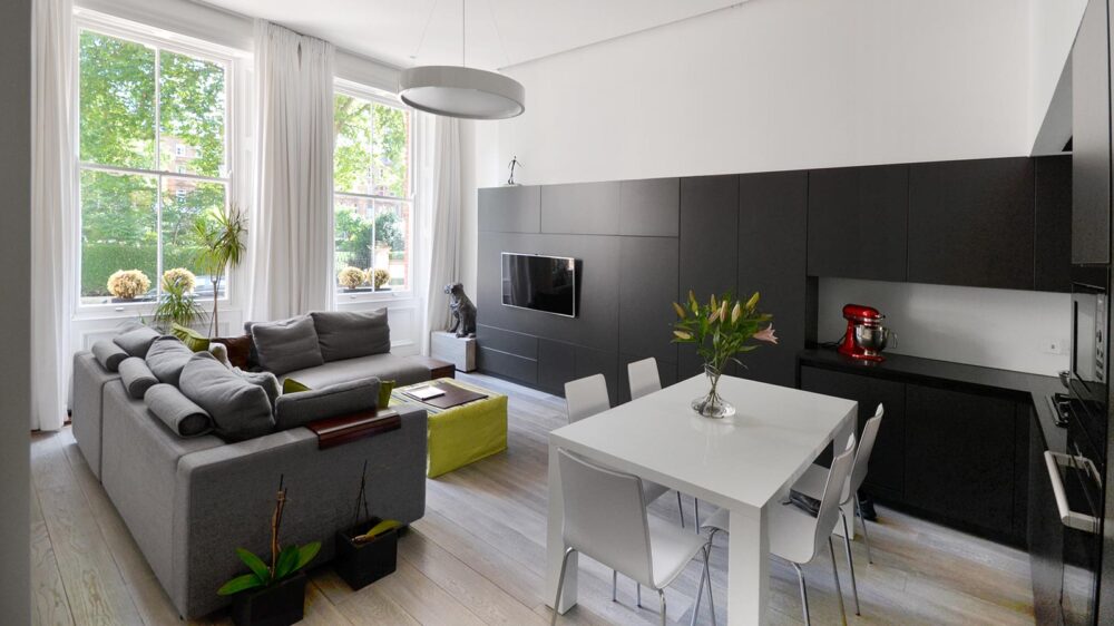 A modern living room featuring a dining table and chairs, showcasing a stylish and inviting interior design.